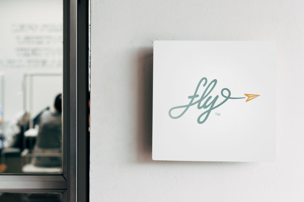 fly! logo mounted on a wall sign in an office