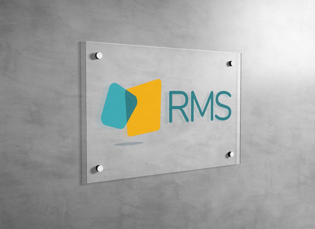 RMS logo printed on a clear plexiglass wall sign and mounted in an office