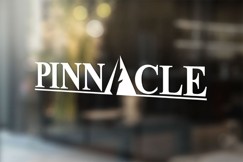 White pinnacle logo decal on a glass office door