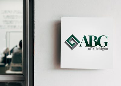ABG of Michigan printed on a square wall sign, mounted next to an office window